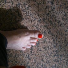 An unevenly-cut-painted-red toe nail